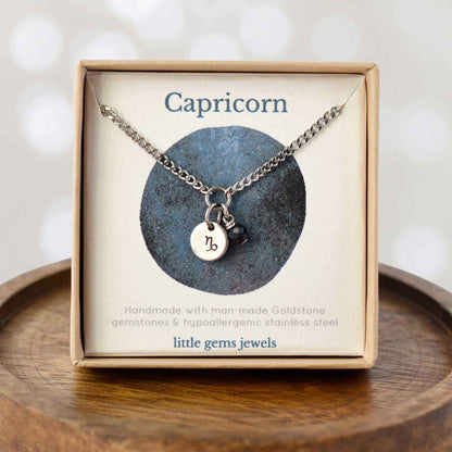 Dainty Capricorn zodiac sign necklace in eco-friendly gift box on wooden coaster