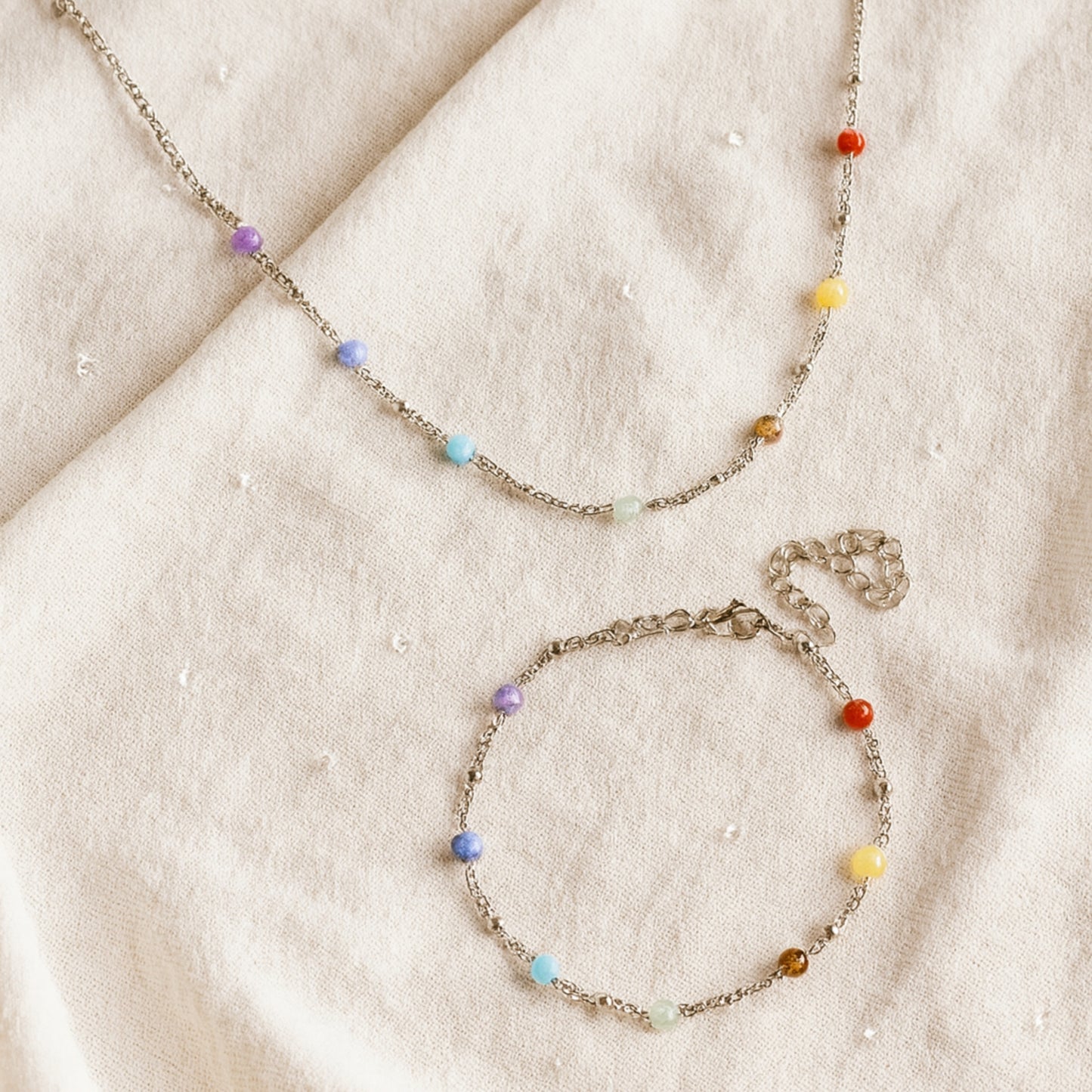Two beaded necklaces on a beige fabric background