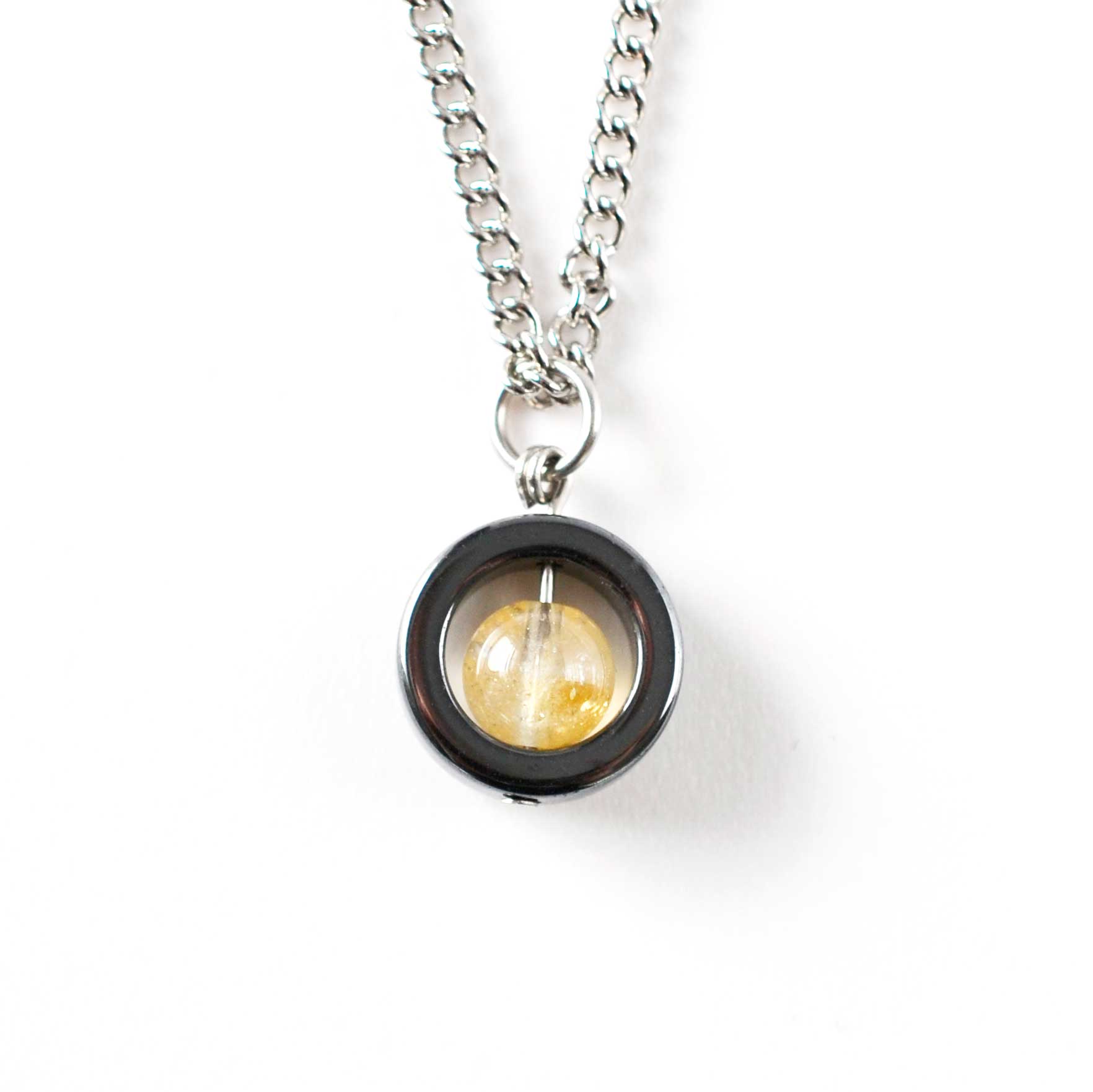 Citrine gemstone fidget spinner necklace on white background.