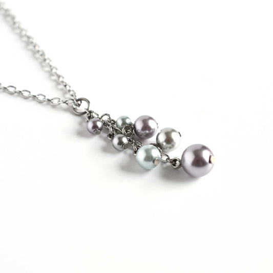 Side view of faux pearl cluster pendant on white background