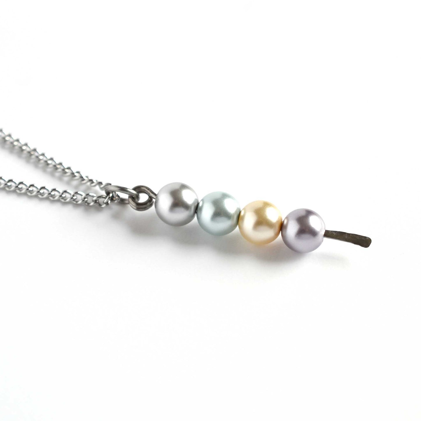 Close up of faux pearl stack pendant on white background
