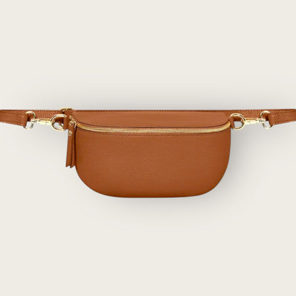 Brown belt bag with gold zipper on a light beige background