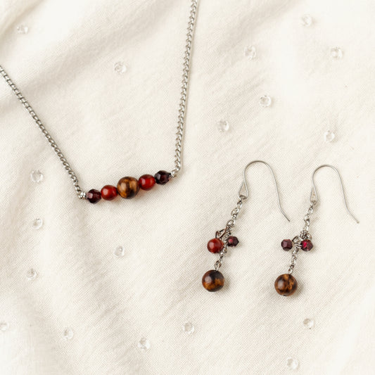 Jewelry set with necklace and earrings featuring beads on a textured white background