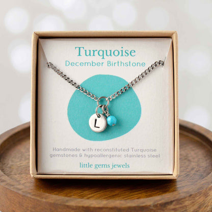Turquoise December Birthstone necklace with hand stamped initial inside an eco-friendly gift box sitting on wooden coaster