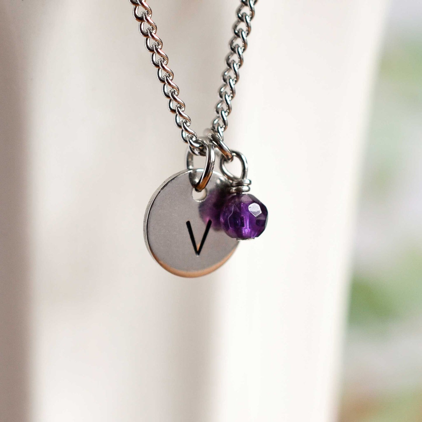 Close up of initial V letter pendant with Amethyst birthstone charm