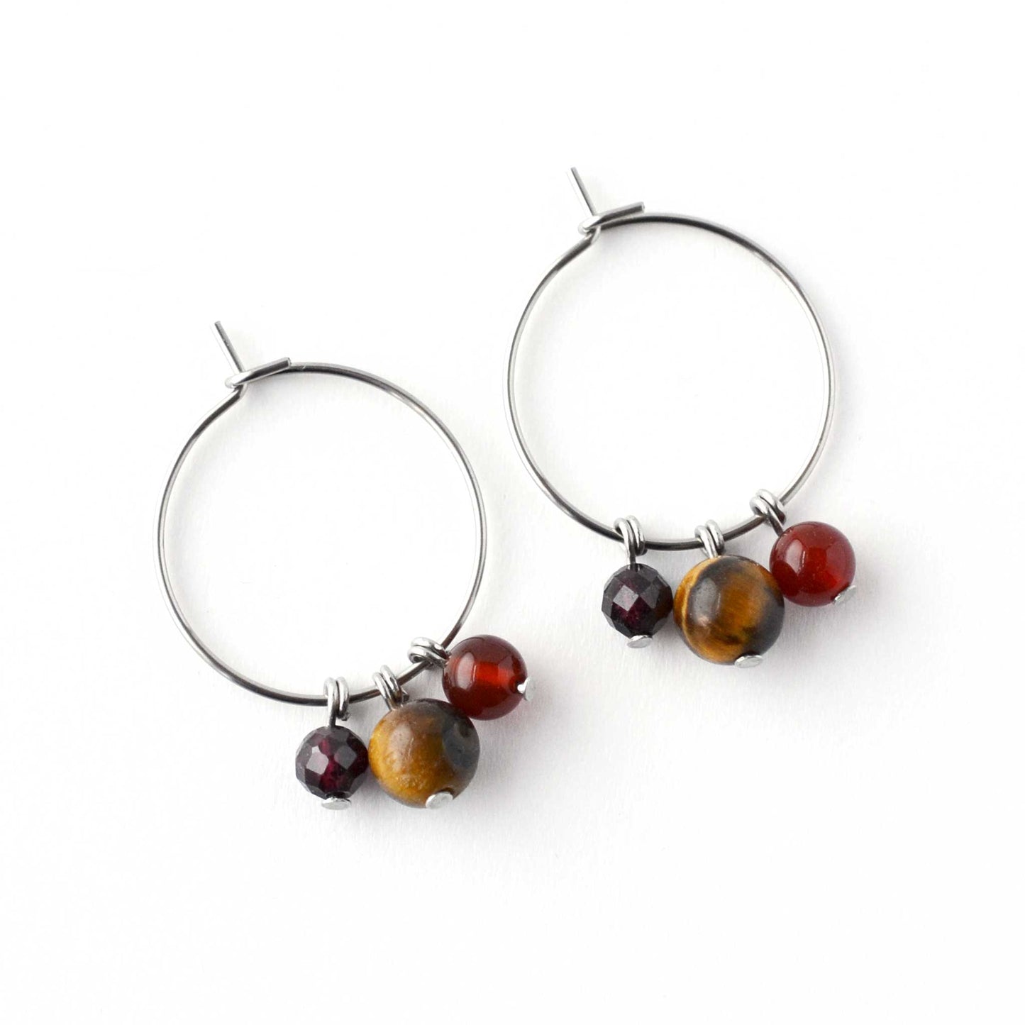 Flatlay Tigers Eye, Carnelian & Garnet gemstone hoop earrings on white background