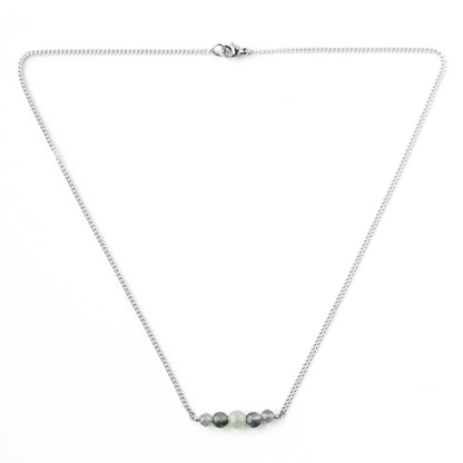 Flatlay of dainty green gemstone necklace with stainless steel chain and lobster clasp