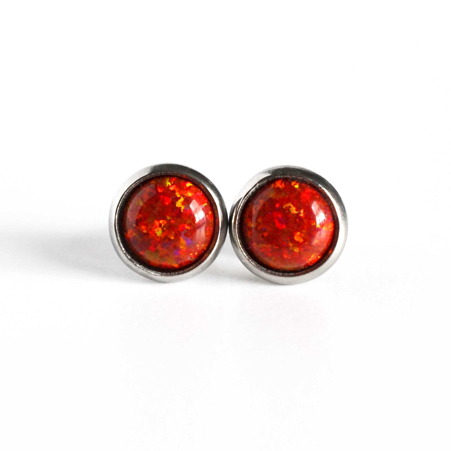 Front view of red Opal stud earrings on white background