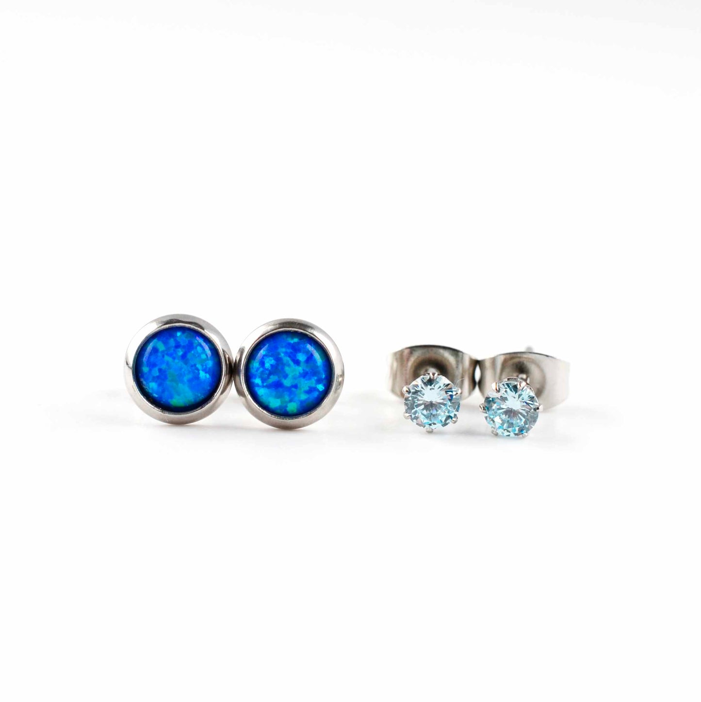 Front view of blue lab opal studs and aqua CZ stud earrings on white background.