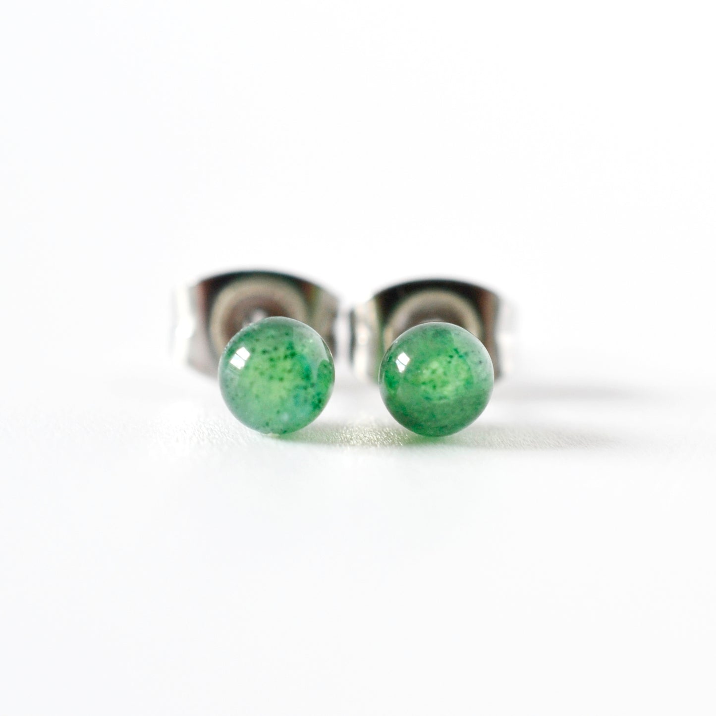 Front view of green gemstone ball stud earrings on a white background