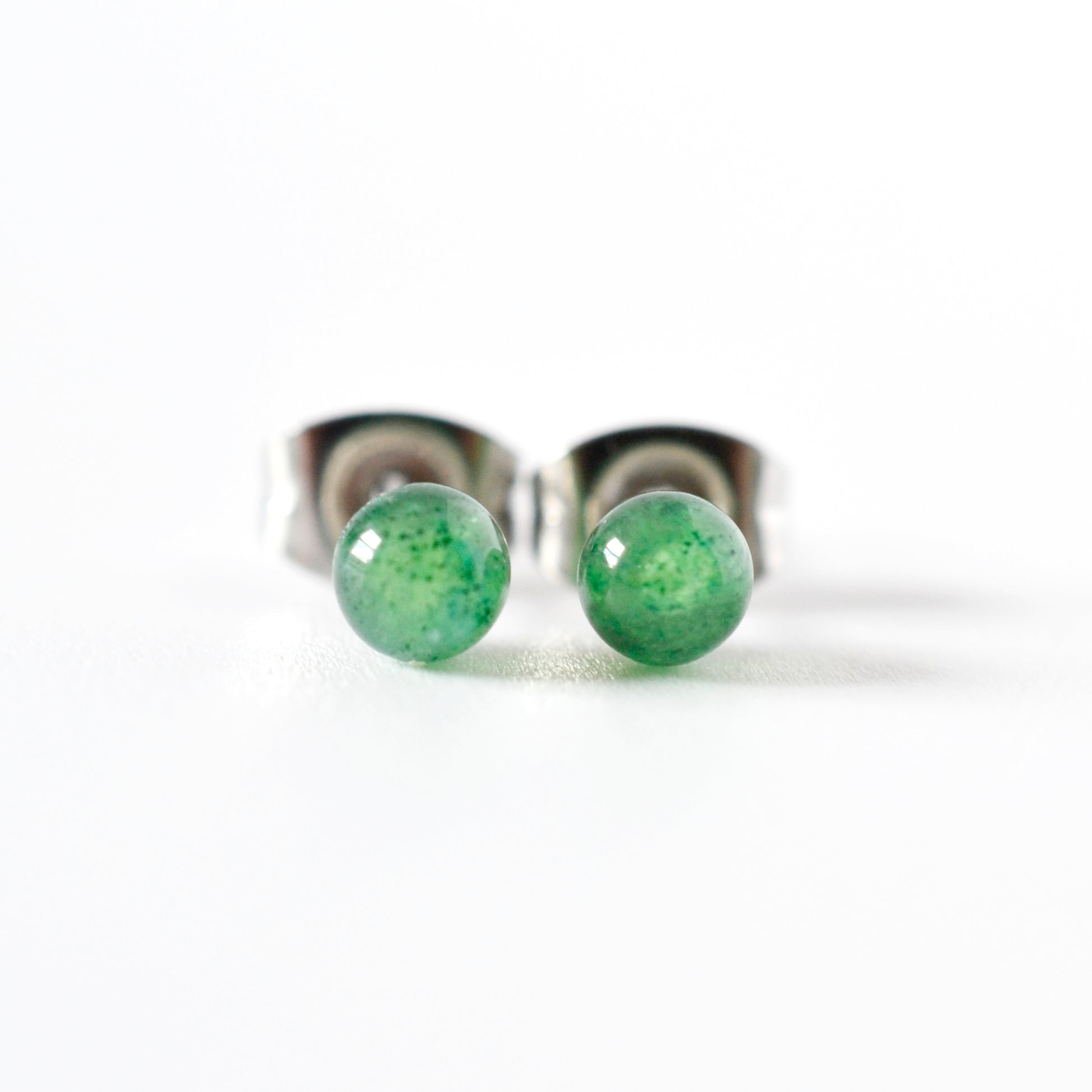 Front view of green gemstone ball stud earrings on a white background