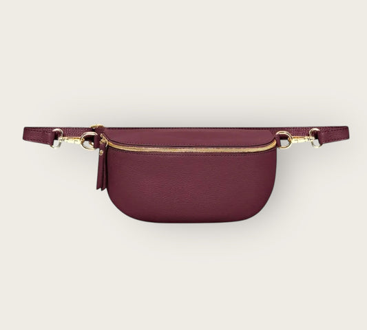 Maroon waist bag with gold accents on a light gray background