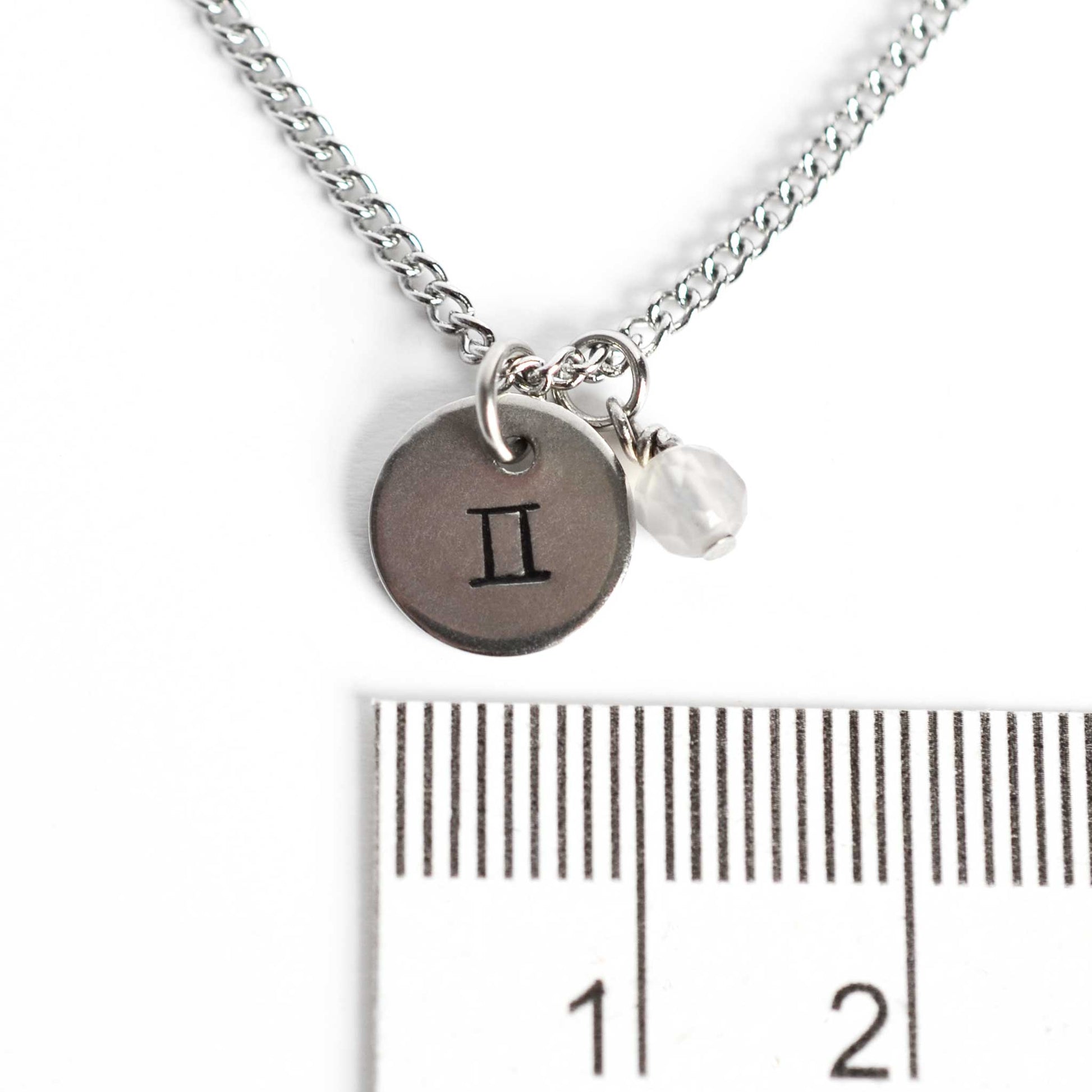 1cm diameter disc pendant with hand stamped Gemini zodiac sign and 4mm Agate gemstone charm