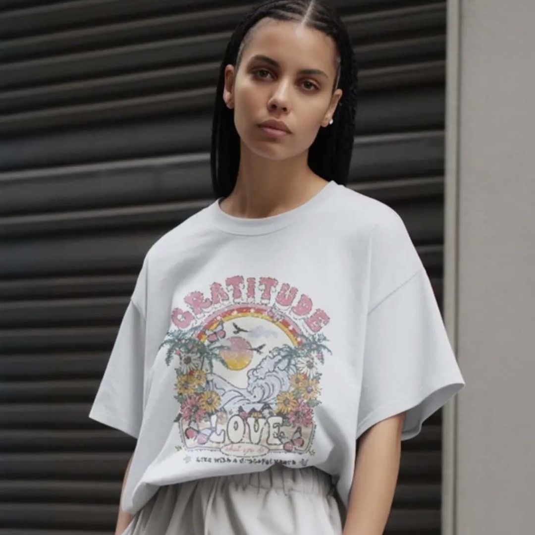 Woman wearing a white t-shirt with a colorful graphic design in an urban setting
