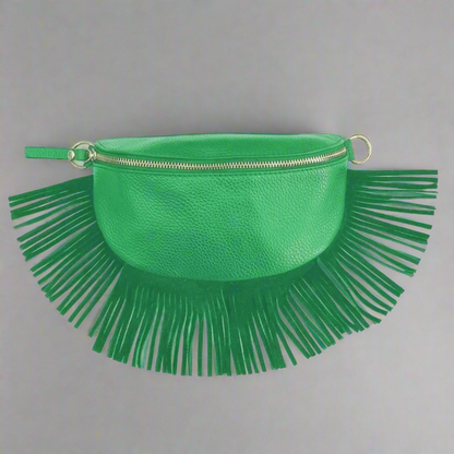 Green clutch bag with fringe details on a gray background