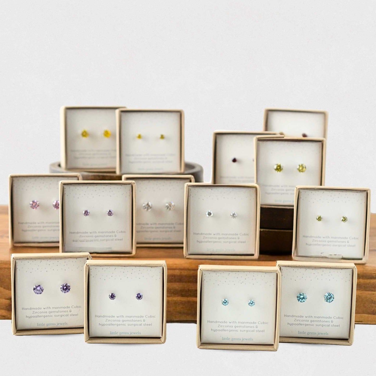 Different coloured CZ stud earrings in eco friendly gift boxes in tiered display