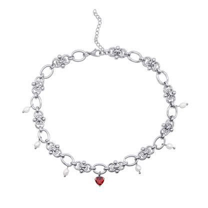 Stainless steel necklace with a red heart charm on a white background