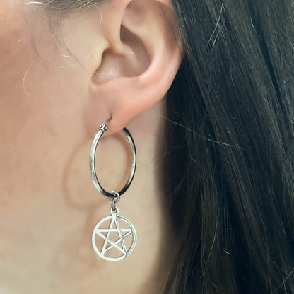 Steel hoop earring with a pentagram charm worn by a person.