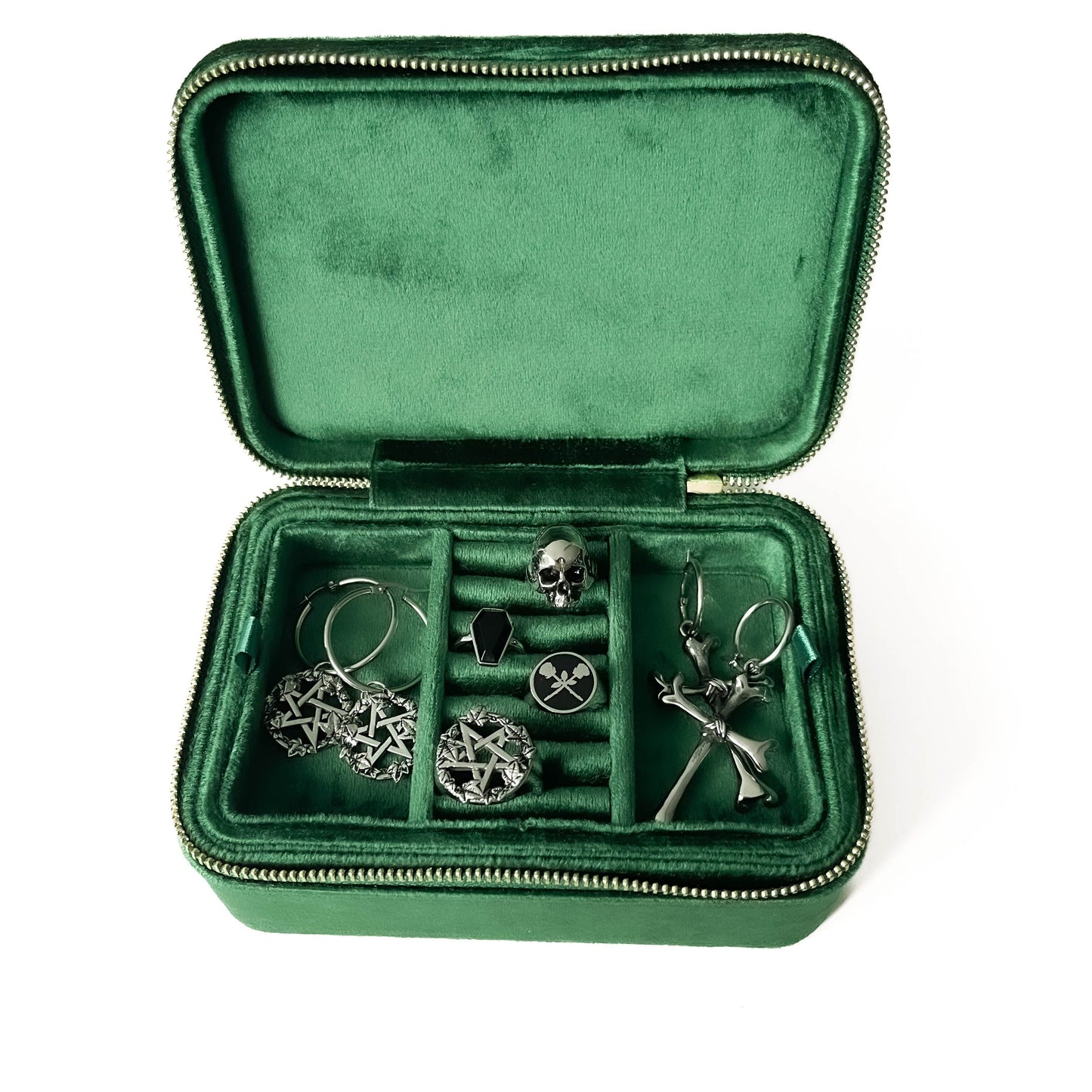 Green jewelry case with steel earrings and jewellery inside on a white background