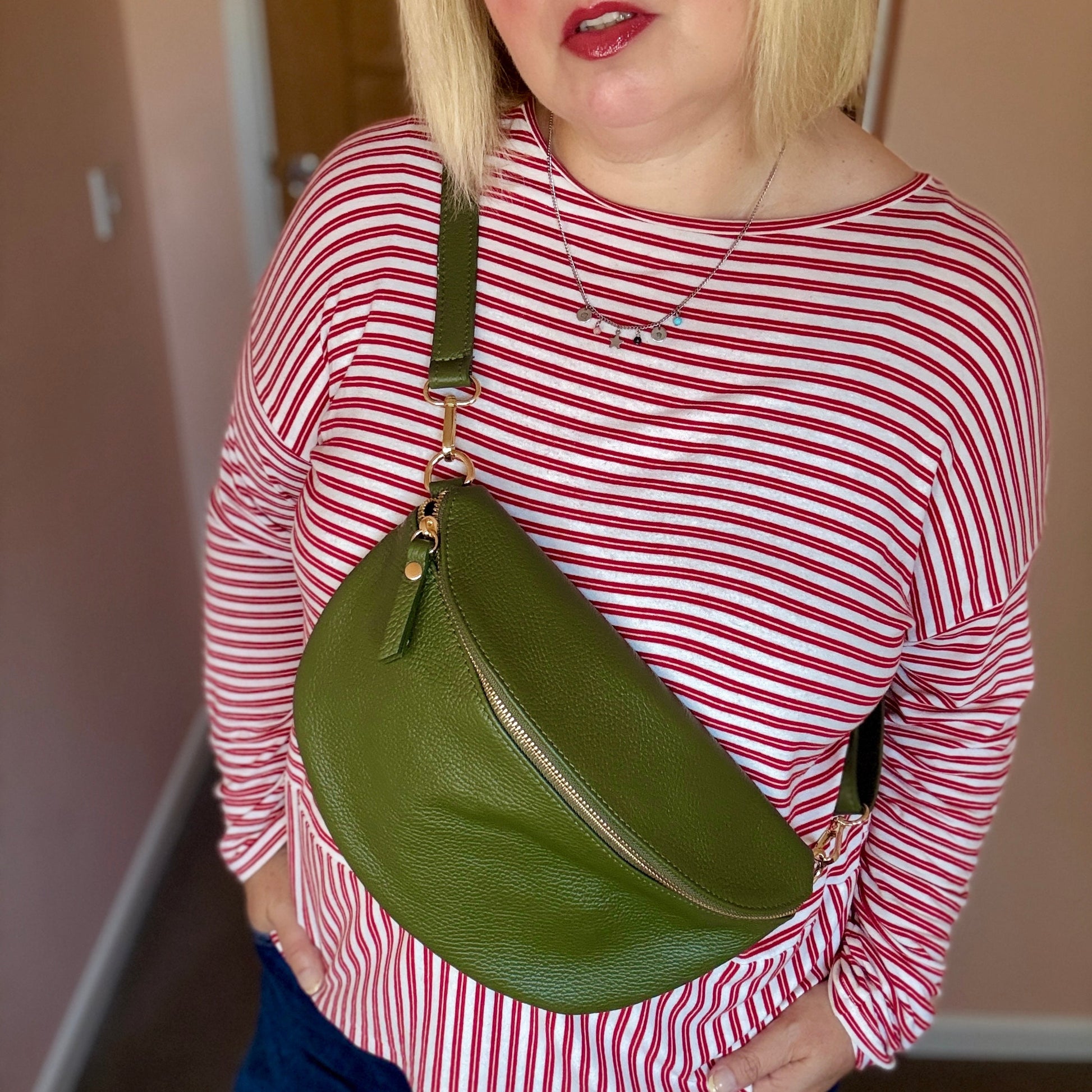 Person wearing a red and white striped shirt with a green bag over one shoulder.