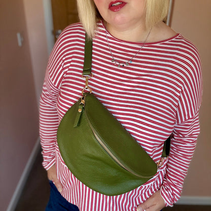 Person wearing a red and white striped shirt with a green bag over one shoulder.