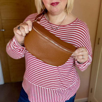 Woman holding a brown leather bag indoors