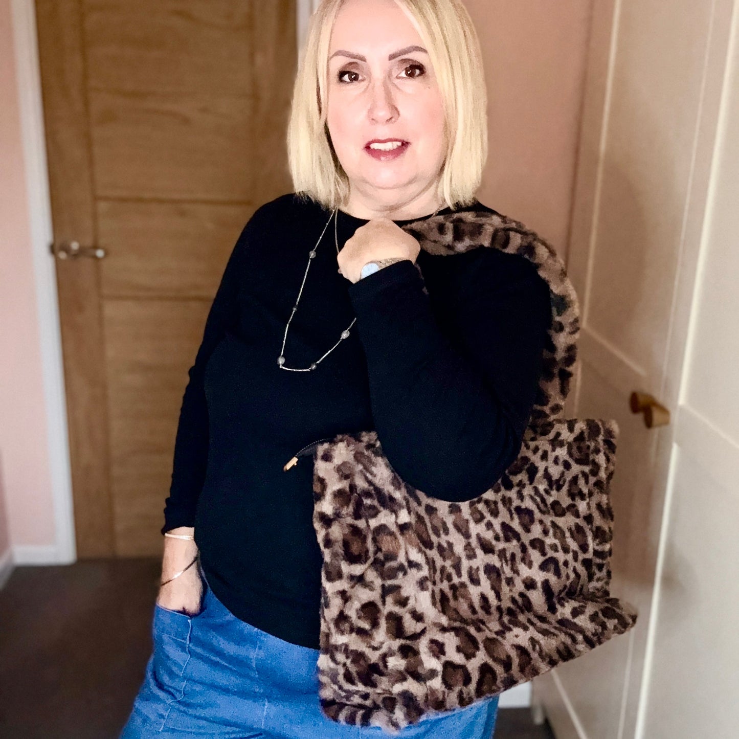 Woman holding a leopard print bag indoors