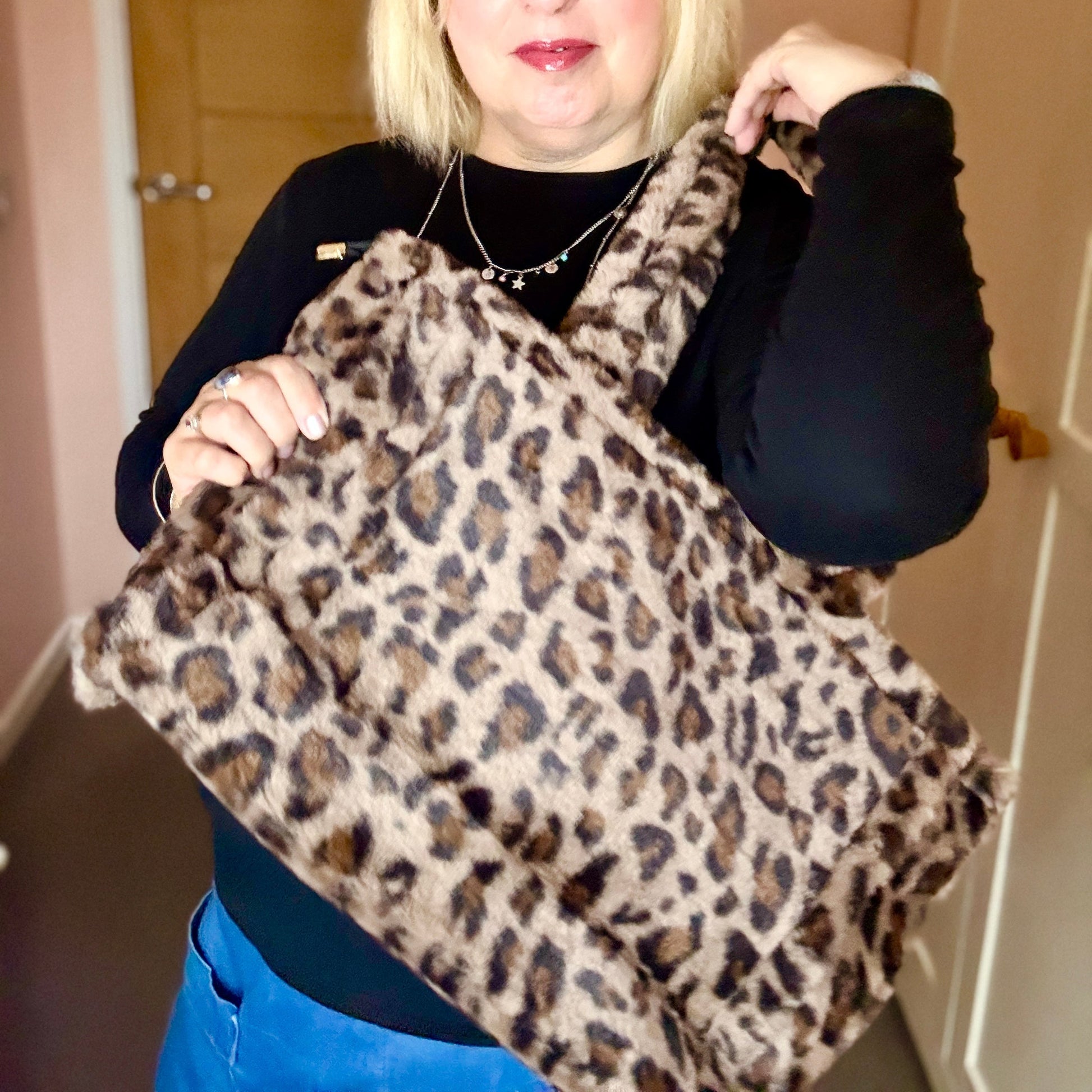 Woman holding a leopard print bag indoors