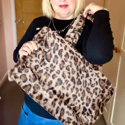 Woman holding a leopard print bag indoors