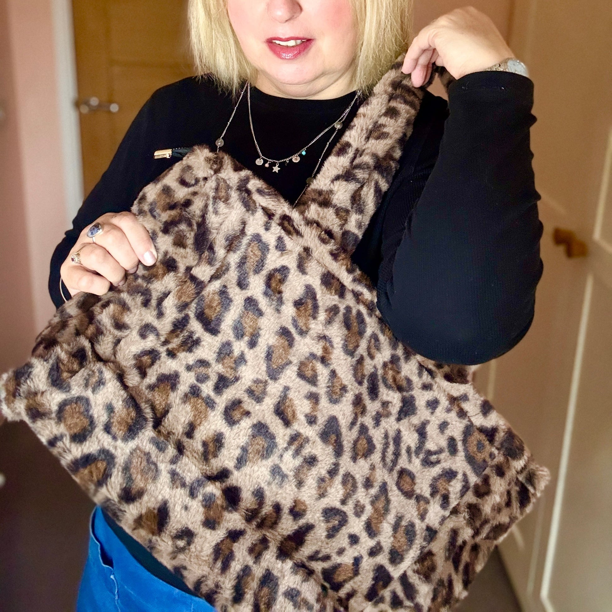 Woman holding a leopard print bag indoors