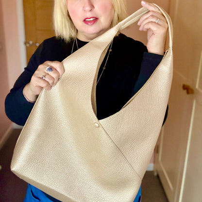 Woman holding a gold handbag indoors