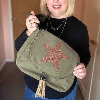 Woman holding a green bag with a star design indoors