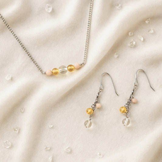 Necklace and earrings with yellow gemstone beads on a beige fabric background