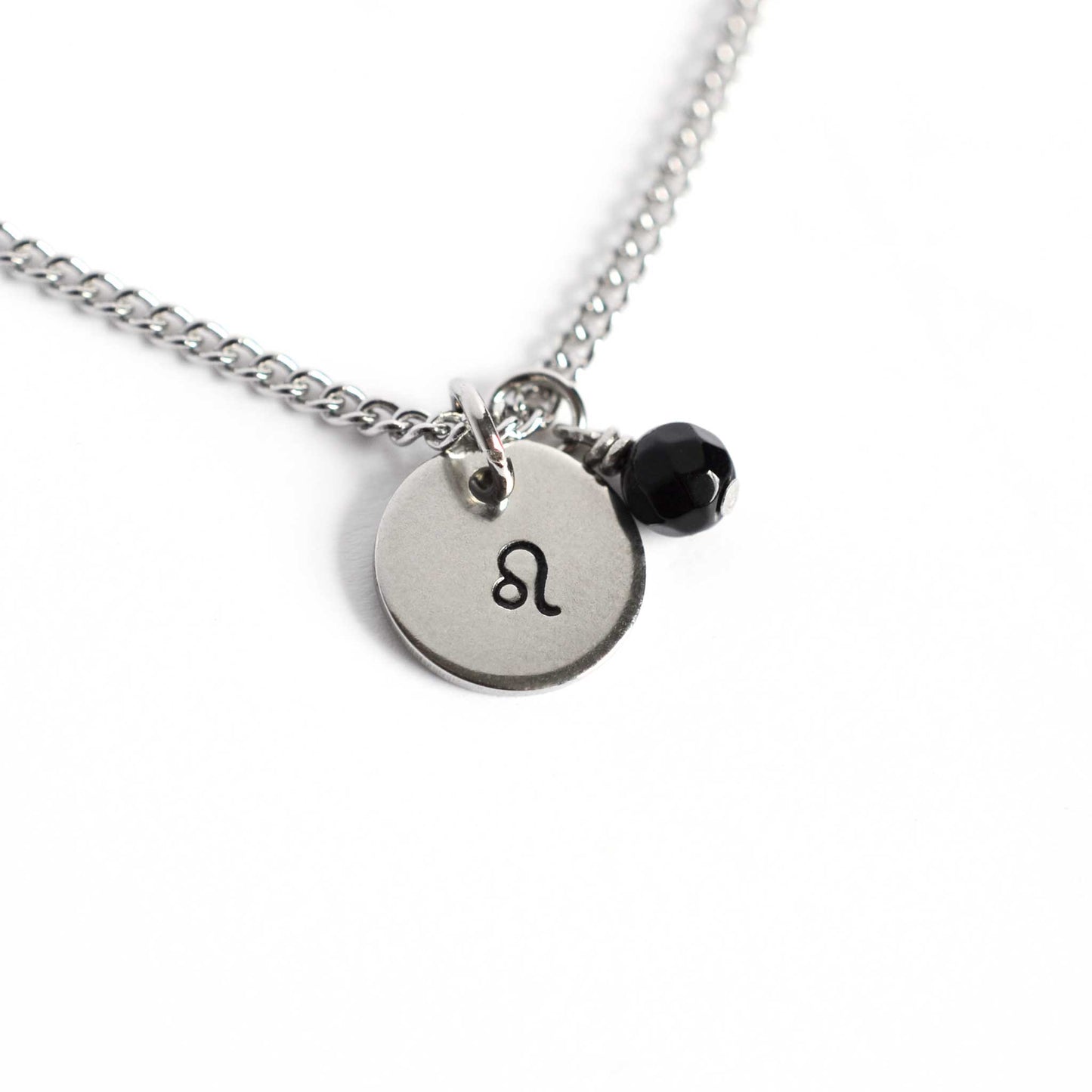 Leo Zodiac pendant necklace with tiny Onyx gemstone charm on white background