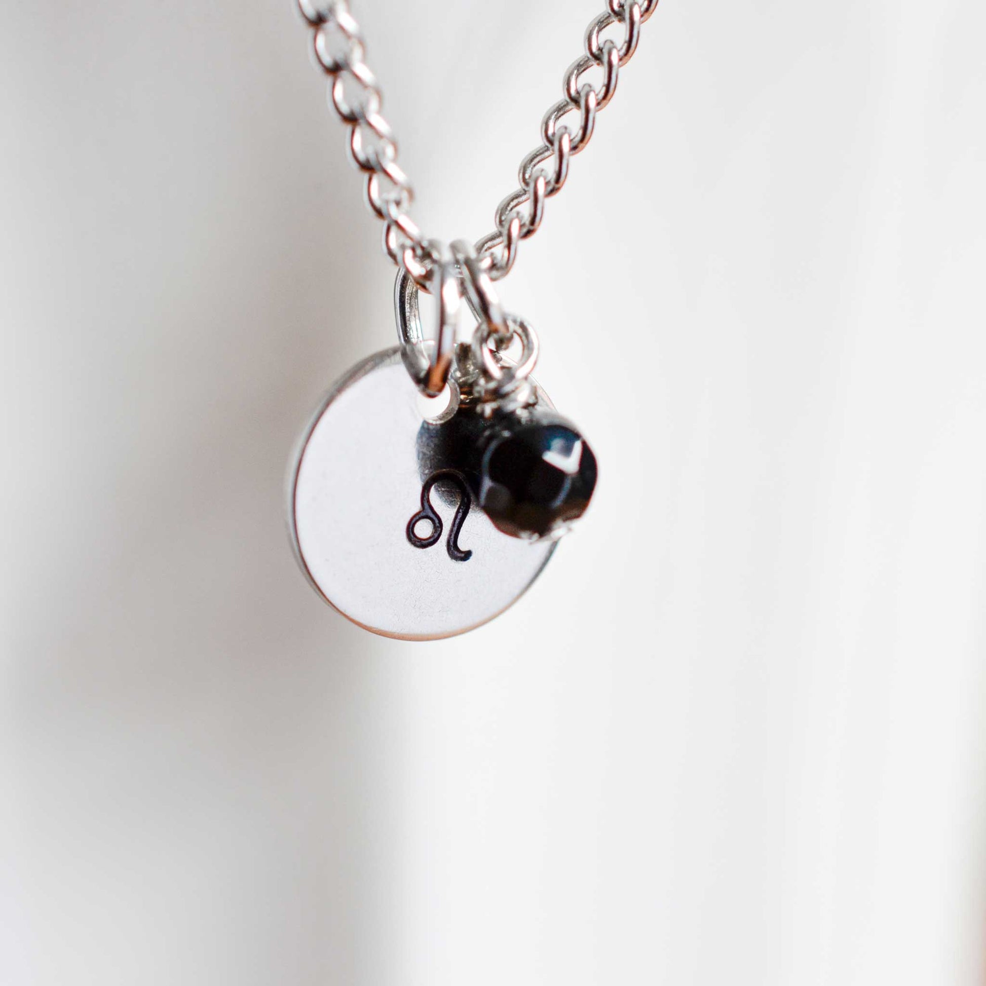 Close up of Leo zodiac sign necklace with Onyx gemstone charm on stainless steel chain