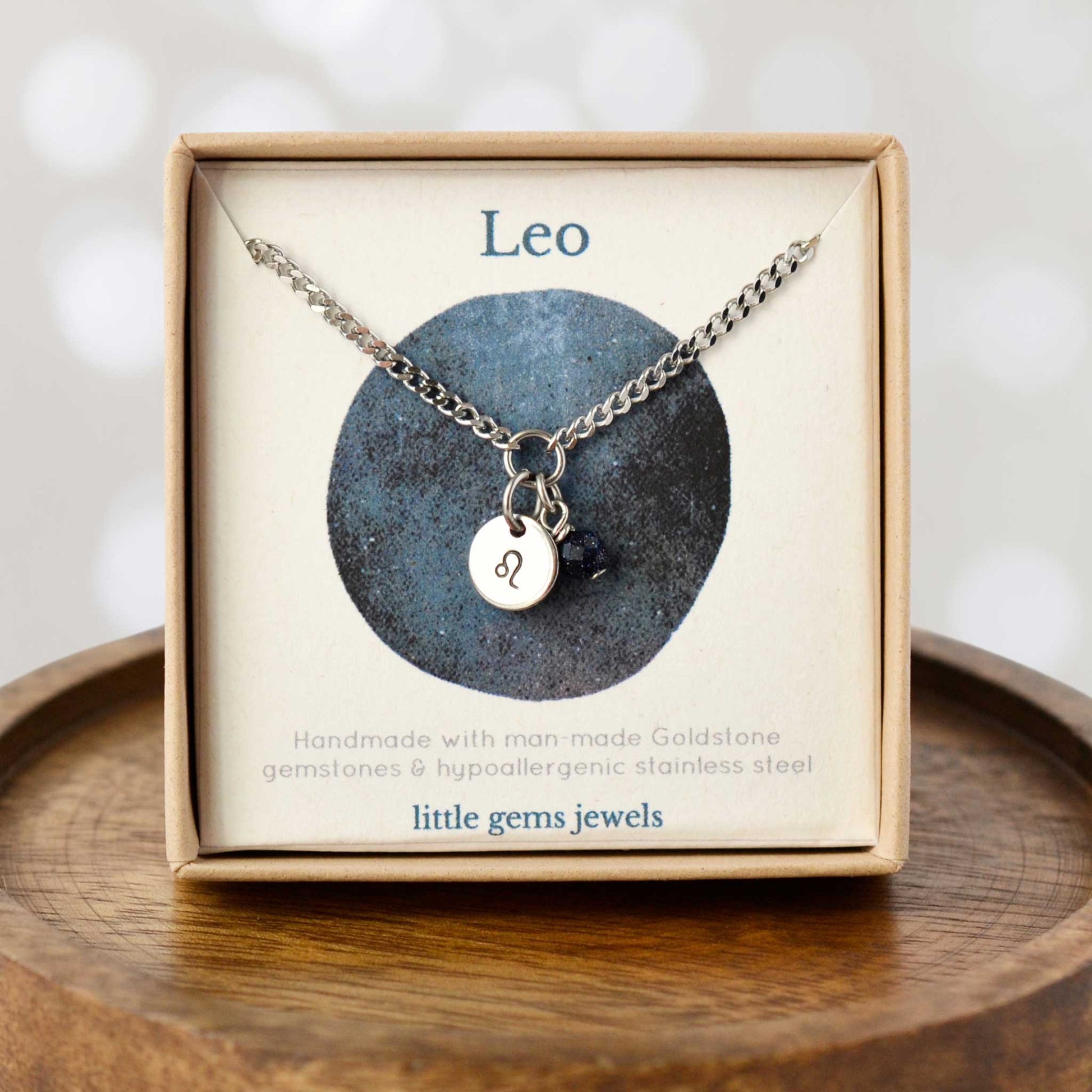 Dainty Leo zodiac sign necklace in eco-friendly gift box on wooden coaster