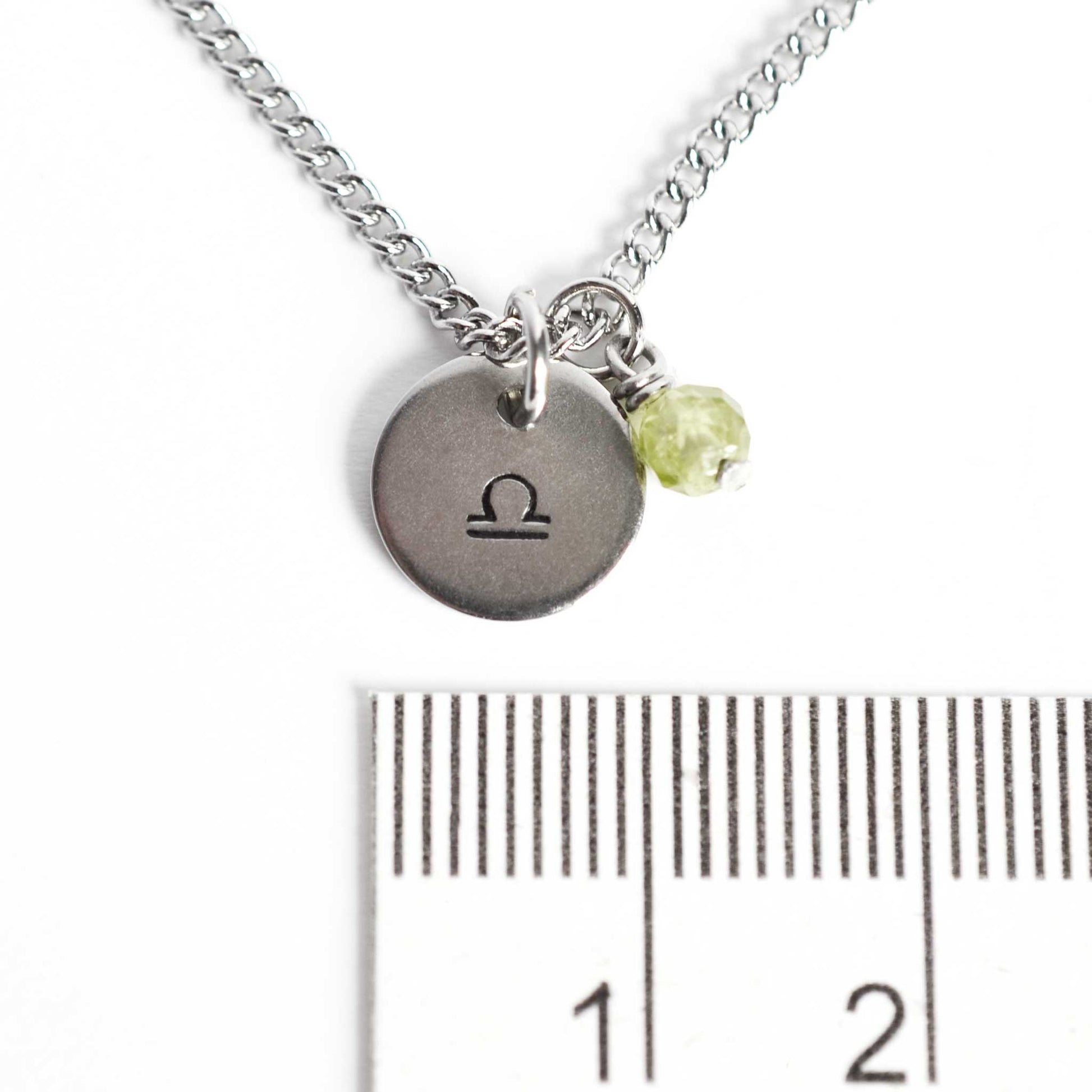 1cm diameter disc pendant with hand stamped Libra zodiac sign and 4mm Peridot gemstone charm