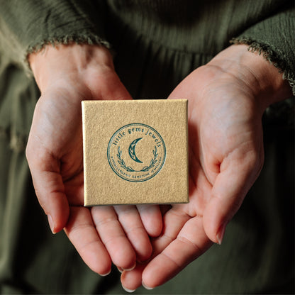 Eco jewellery box with a logo held in hands against a blurred background