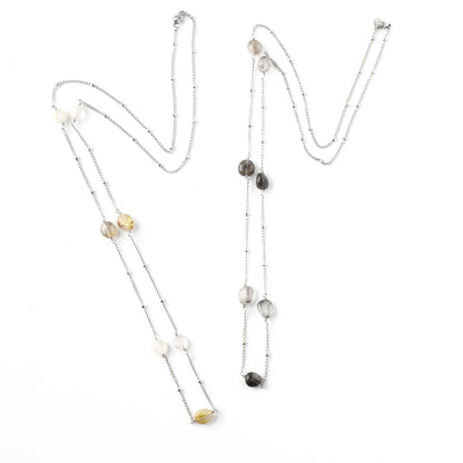Two long Quartz gemstone necklaces lying on white background