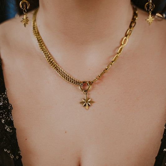 Gold chain necklace with a star pendant worn by a person.