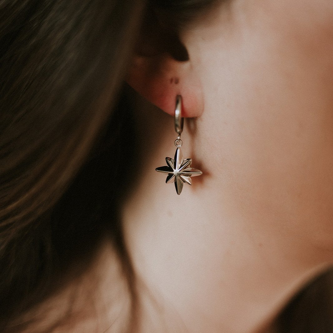 Close-up of a person wearing a star-shaped earring.