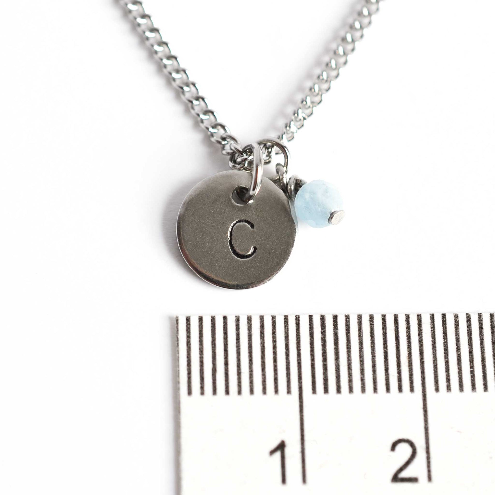 1cm diameter disc pendant with hand stamped initial and 4mm March birthstone charm