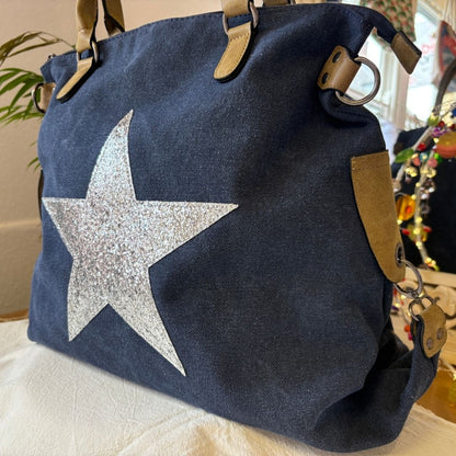 Navy blue bag with a silver star on a light surface
