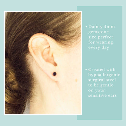 Woman wearing tiny dark blue gemstone stud earring in earlobe