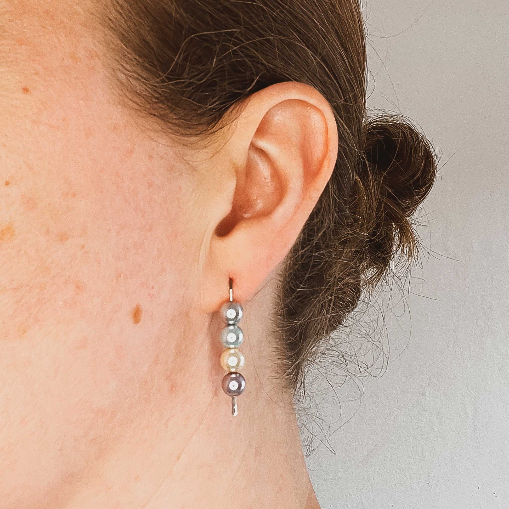 Woman wearing faux pearl stack earring in earlobe