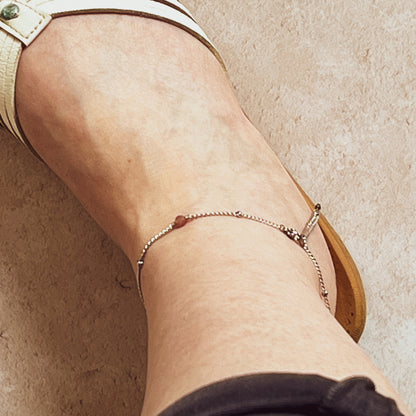 View from above of model wearing ankle chain with flip flops and cut off trousers