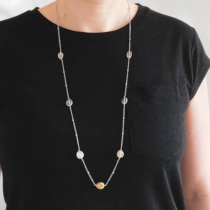 Woman wearing plain black t shirt and long necklace with Quartz gemstones
