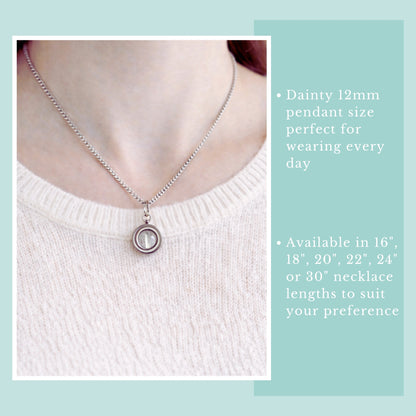 Model wearing light pink jumper and clear crystal fidget spinner necklace.