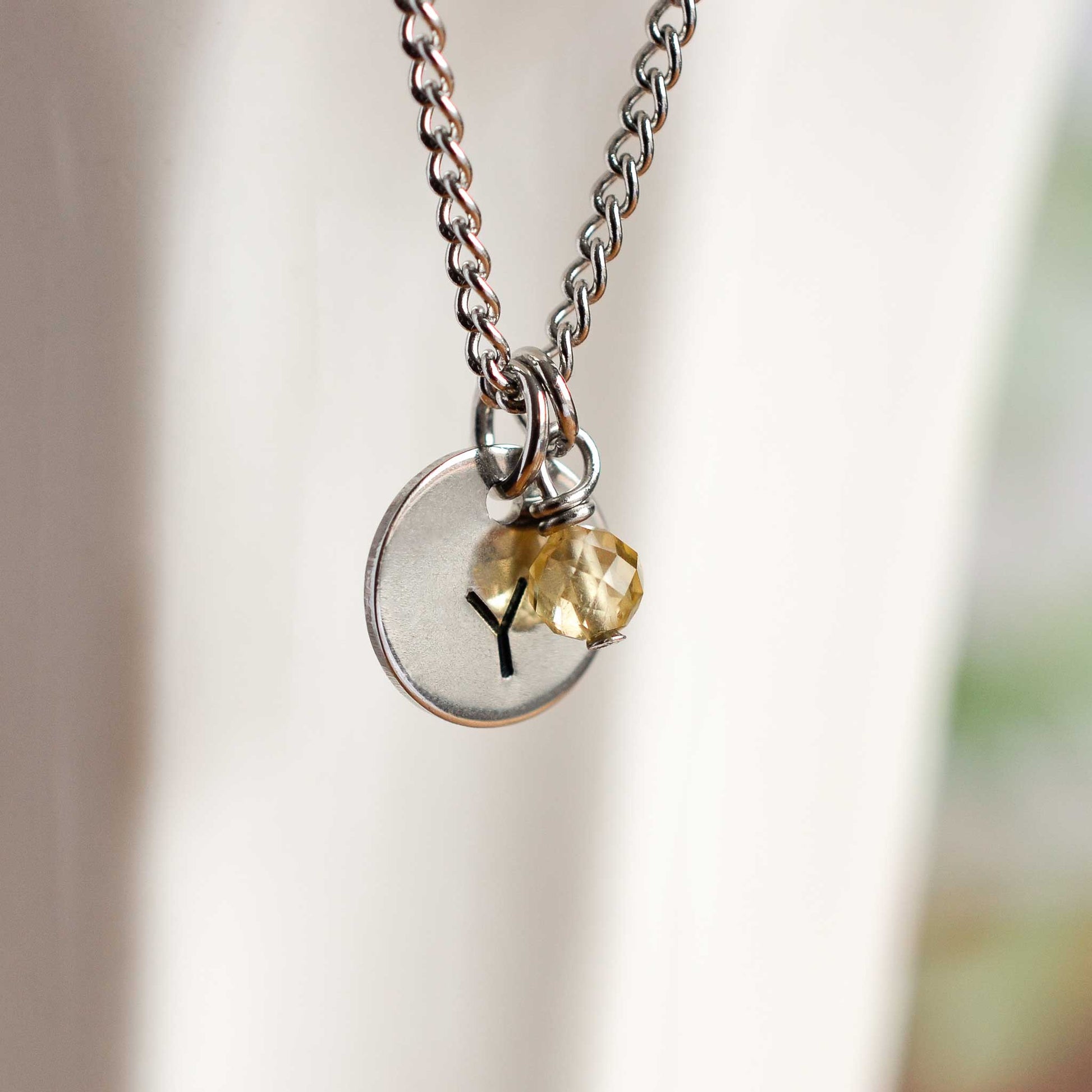 Close up of letter Y disc initial pendant with Citrine November birthstone charm