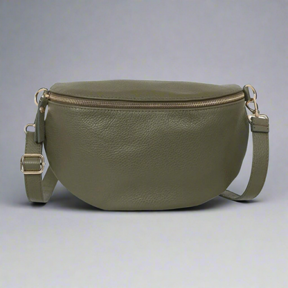 Green leather bag with a strap on a gray background